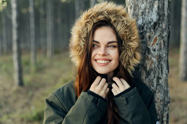 Sonbahar ceketli bir kadın, bir ağacın yanında seyahat ediyor. — Stok fotoğraf