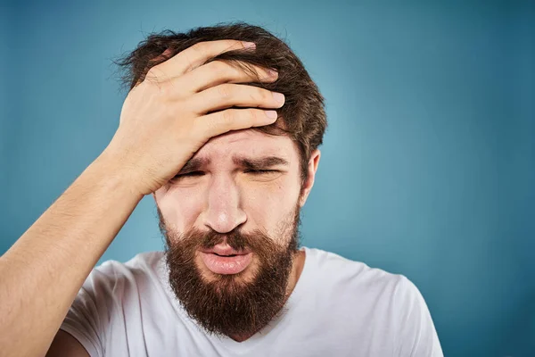 Baard man ontevreden gezicht expressie emoties close-up blauw achtergrond wit t-shirt — Stockfoto