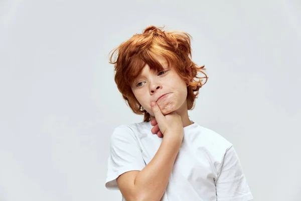 Röd-hårig pojke med ett sorgligt uttryck i ansiktet lyhörd look vit t-shirt beskärda utseende — Stockfoto