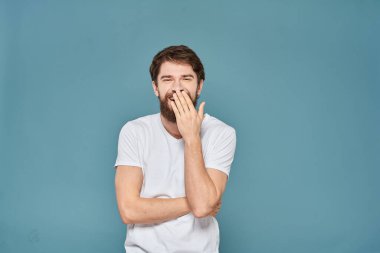 Beyaz tişörtlü, el kol hareketleri yapan, stüdyosu kesilmiş biri.