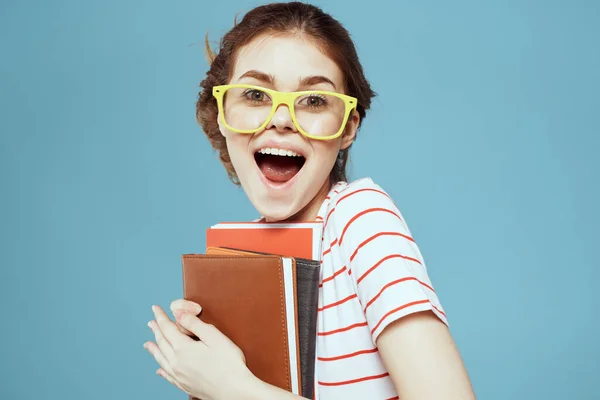 Estudante bonita com blocos de notas e em óculos amarelos em um fundo azul instituto de ciência da educação — Fotografia de Stock
