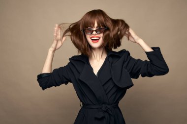 Güzel, koyu renk ceketli, zarif bir kadın içeride gülümsüyor. 