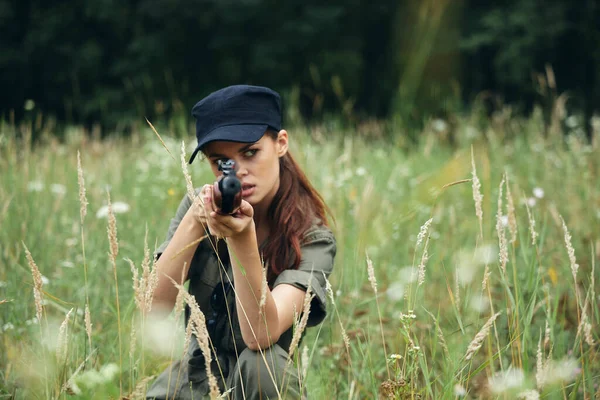 Mulher soldado no abrigo segurando arma na mão caça estilo de vida black cap — Fotografia de Stock