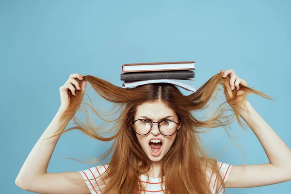 Estudante feminino enérgico com blocos de notas e óculos modelo fundo azul — Fotografia de Stock