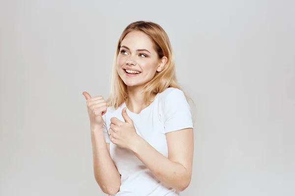 Carino bionda bianco t-shirt gesto con le mani stile di vita luce sfondo — Foto Stock