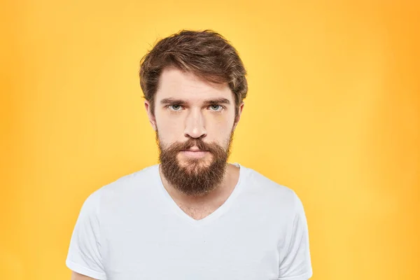 Mann i hvite t-skjorte følelser studio gester med hendene misfornøyd ansiktsuttrykk gul bakgrunn – stockfoto