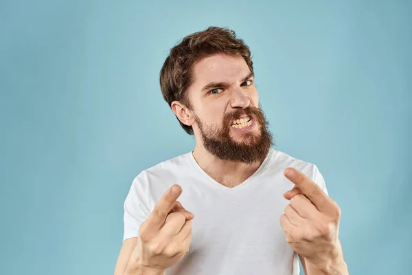 Бородатий чоловік у білій футболці емоції жести з руками невдоволений вираз обличчя синій фон — стокове фото