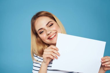 Elinde kağıt şeritli tişört tutan kadın Boşluğu kopyalanmış mavi arkaplan