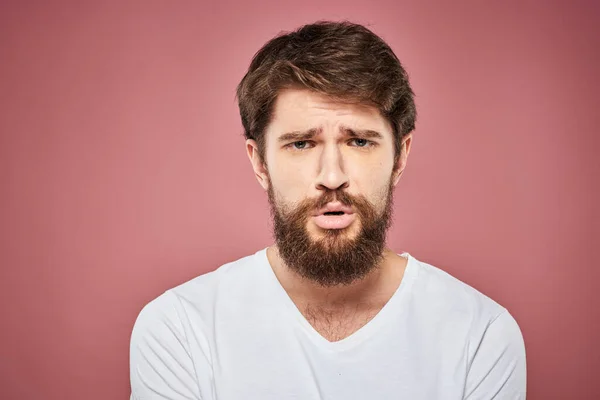 Homem emocional branco t-shirt triste facial expressão rosa fundo — Fotografia de Stock