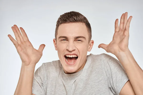 Cheerful homem emocional cinza t-shirt gestos com as mãos estúdio estilo de vida — Fotografia de Stock