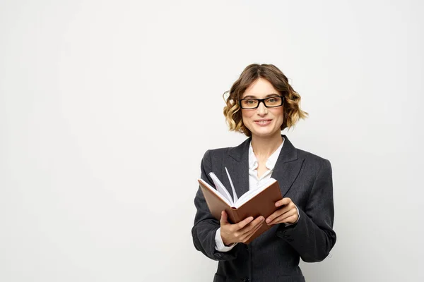 Biznes kobieta z notatnikiem i okulary pracy lekkie tło przycięte widok garnitur modelu. — Zdjęcie stockowe