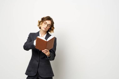 El fenerindeki kitapla çalışan kadın klasik takım elbiseli gözlüklü kafa.