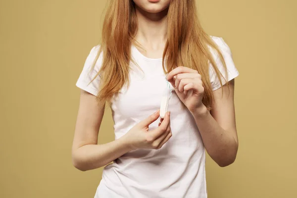 Girl with a tampon in her hand the size of the appearance of the critical days of menstruation — Stock Photo, Image