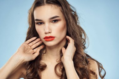 Zarif esmer, modaya uygun, parlak, makyajlı, çıplak omuzlar yakın plan, mavi arka plan.