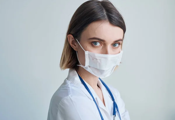 Doctora con máscara médica y estetoscopio alrededor del cuello —  Fotos de Stock