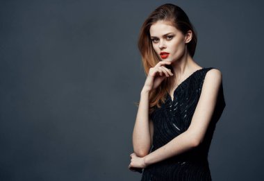 Gri arka planda gece elbisesi giymiş romantik bir kadın.