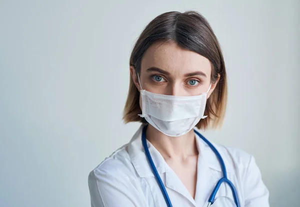 Doctora con máscara médica y estetoscopio alrededor del cuello —  Fotos de Stock