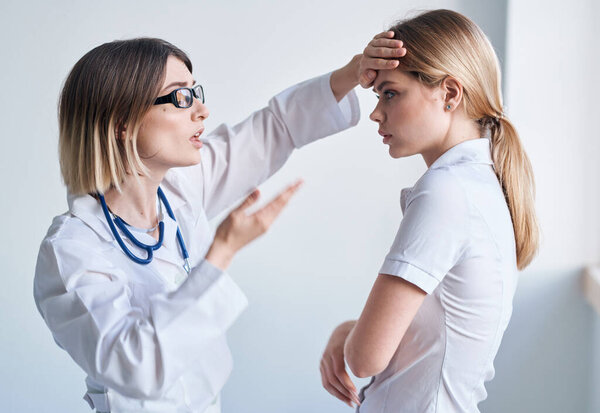 Doctor in a medical gown measure the temperature of a female patient providing medicine services