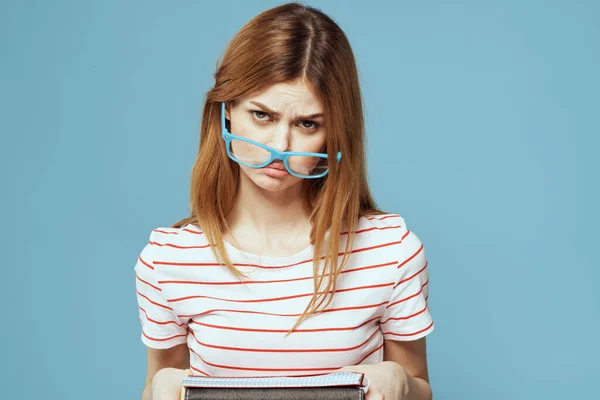 Девушка в модных очках с ноутбуками в руках на синем фоне обрезанный вид — стоковое фото