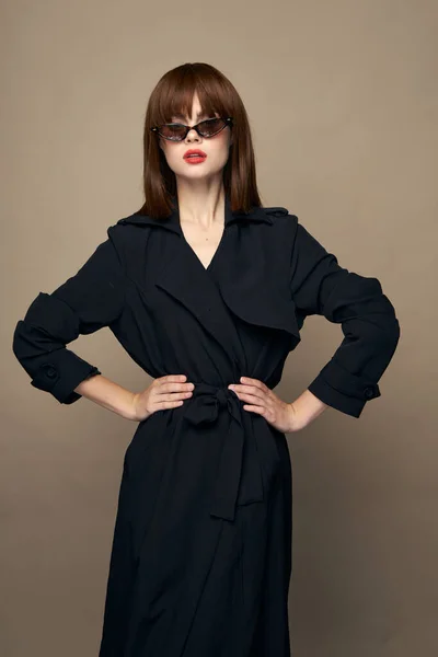 Luxe model donkere jas aantrekkelijk uiterlijk verheugen zich op een geïsoleerde achtergrond — Stockfoto