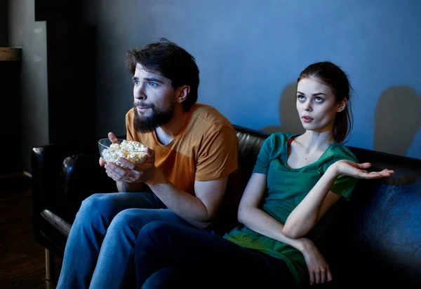 Männer und Frauen auf der Couch In einem dunklen Raum, der einen Horrorfilm anschaut — Stockfoto