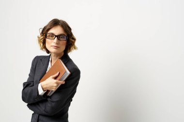 El fenerindeki kitapla çalışan kadın klasik takım elbiseli gözlüklü kafa.