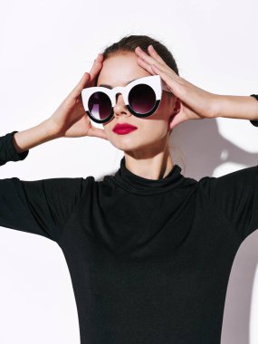 Güneş gözlüklü kadın ve siyah kazaklı akşam makyajı portresi. 