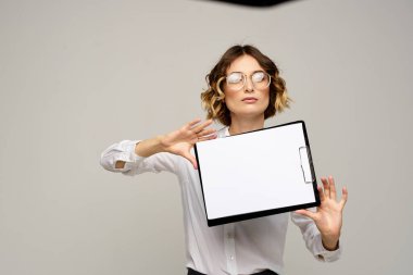 Açık tişörtlü bir iş kadını ve dosyasının içinde iş görüşü kesilmiş belgeler var.