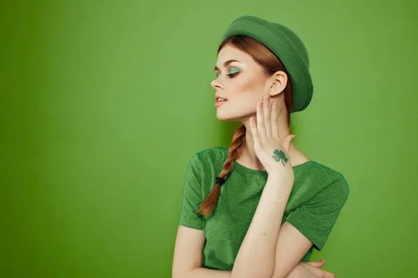 Belle fille avec un trèfle sur sa main sur un fond vert vacances St. Patricks Day chapeau amusant sur sa tête — Photo