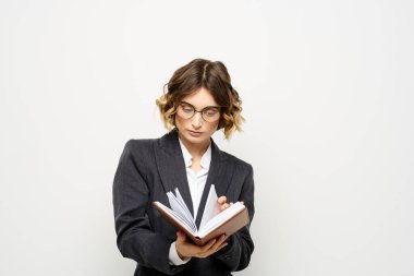 El fenerindeki kitapla çalışan kadın klasik takım elbiseli gözlüklü kafa.