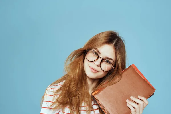 Studente femminile energico con blocco note e occhiali modello sfondo blu — Foto Stock