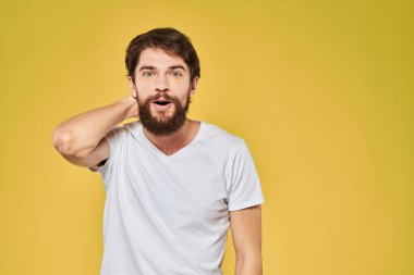 El hareketleriyle hareket eden adam duygusal yaşam tarzı beyaz tişört sarı izole arkaplan