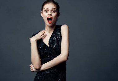 Siyah elbiseli bir kadın elleriyle jest yapar. Duyguları şaşırtır..