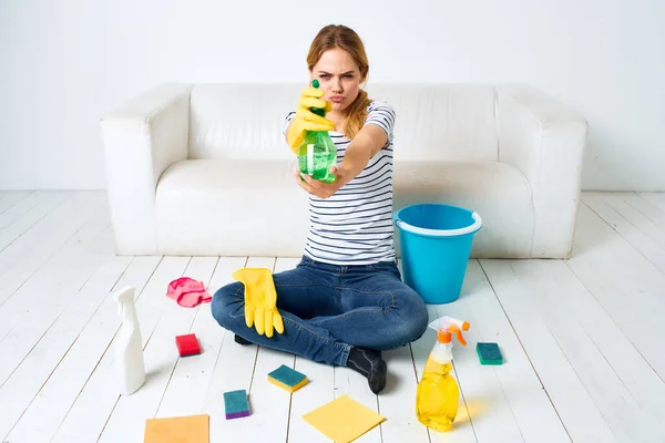 Donna seduta sul pavimento con prodotti per la pulizia servizio di pulizia lavori domestici — Foto Stock