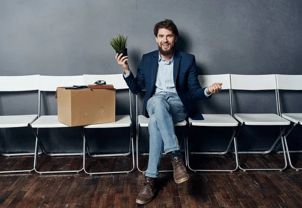 Man sitting on white chair waiting for lighting box job search depression