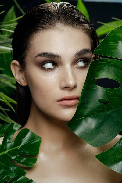 Aspecto natural de una hermosa cara de mujer entre la palmera verde —  Fotos de Stock