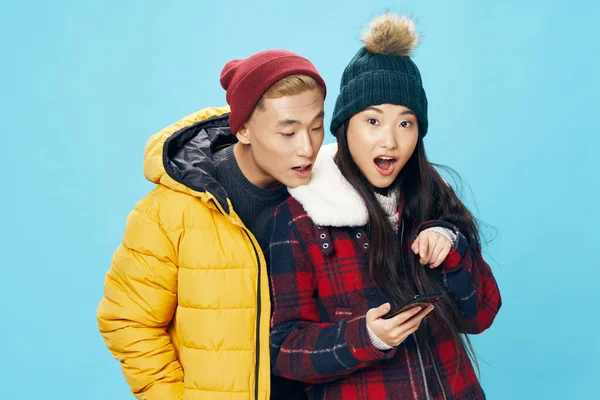 Asiatische Familie Mann und Frau in warmer Kleidung mit einem Handy i — Stockfoto