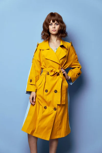 ファッション女性黄色のコートの手にベルトを楽しみにして — ストック写真
