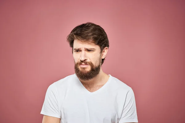 Homem emocional branco t-shirt triste facial expressão rosa fundo — Fotografia de Stock