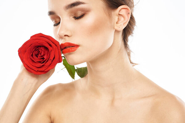 charming brunette girl with makeup on her face and a red rose in her hand