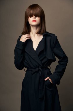 Çekici esmer, açık tenli, şık, soyutlanmış giysiler. 