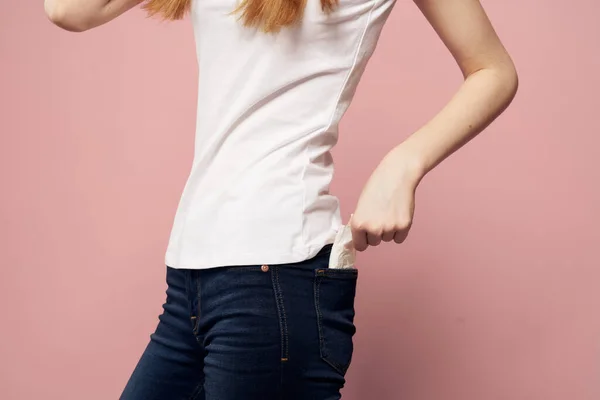 Женщина с блокнотом рядом с джинсами и гигиеническим защитным средством для менструального цикла — стоковое фото
