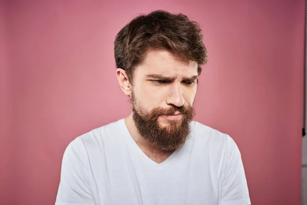 Barbuto uomo in bianco t-shirt emozioni scontento espressione facciale studio rosa sfondo — Foto Stock