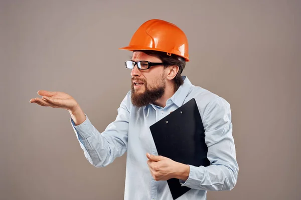 emotional worker man in orange paint documents service construction beige background