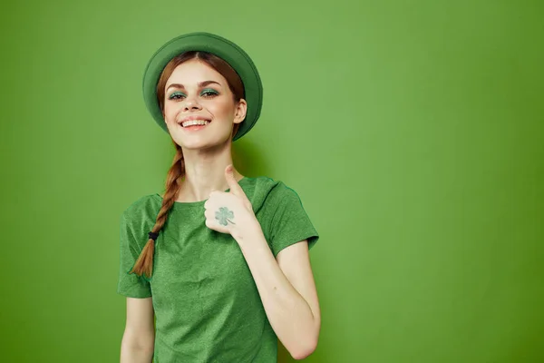 Femme heureuse avec trèfle le jour de la Saint-Patricks en vêtements verts et un chapeau sur sa tête gesticulant avec ses mains — Photo