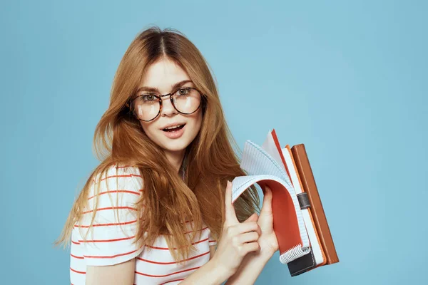 Studente femminile energico con blocco note e occhiali modello sfondo blu — Foto Stock