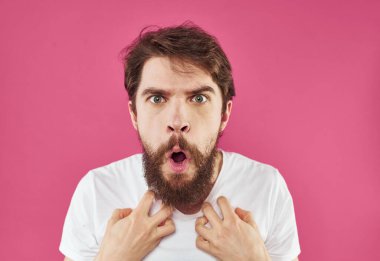 Pembe arka planda şaşmış bir adam. El işaretleri ile model görüntüsü.