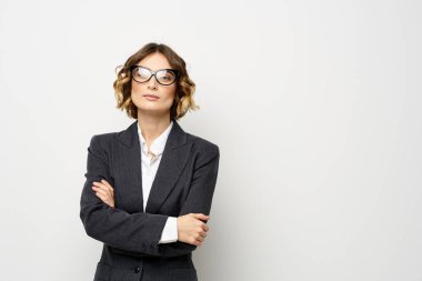 Takım elbiseli kendine güvenen iş kadını, el hareketleriyle hafif bir geçmişi var.