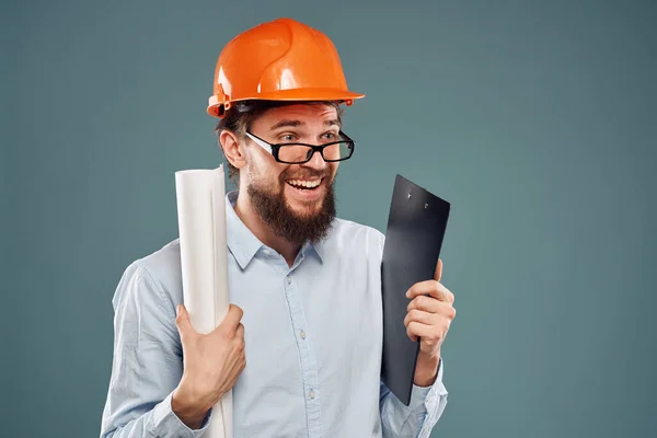 Uomo emotivo indossando occhiali casco arancione cianografie di sicurezza nelle mani lavoro professionale — Foto Stock