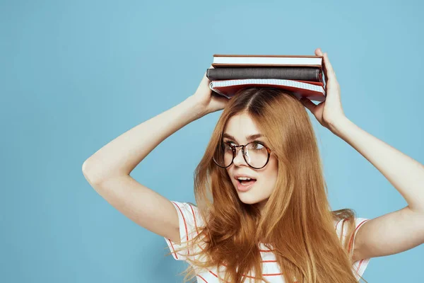 Energieke vrouwelijke student met notitieblokken en bril model blauwe achtergrond — Stockfoto